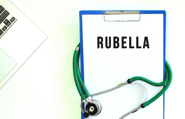 Stethoscope and clipboard with RUBELLA text on white sheet of paper and copy space.