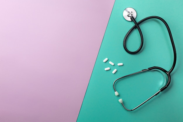 Stethoscope in doctors desk with pills