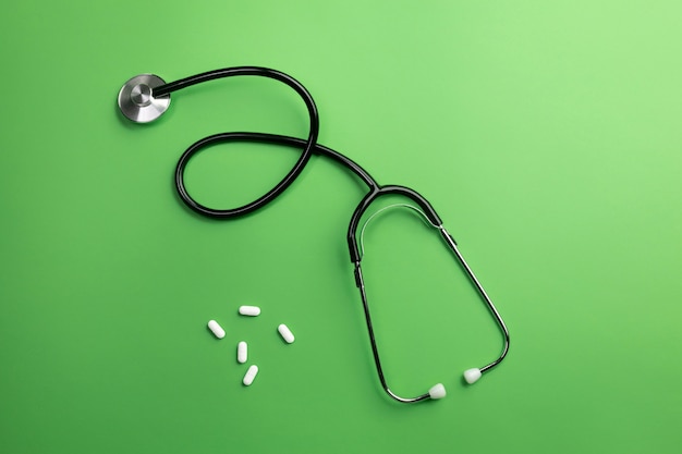 Stethoscope in doctors desk with pills