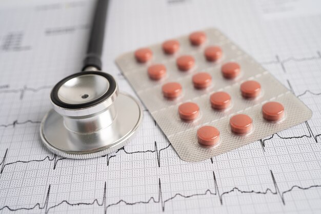 Stethoscope on electrocardiogram with capsule pill, heart wave, heart attack, cardiogram report.