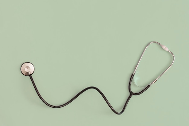 Stethoscope on green background. Top view. Flat lay. Medicine concept.