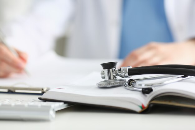 Stethoscope head lying on medical forms