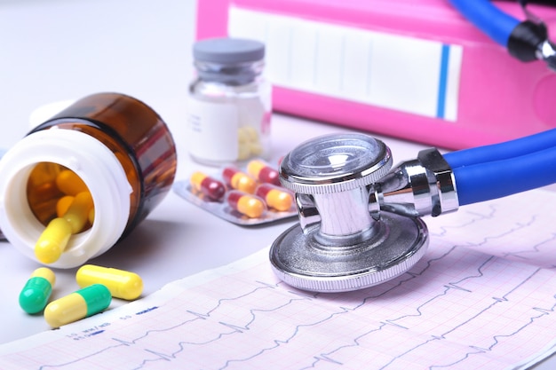 stethoscope lying on RX prescription with assorted pills. Healthy life or insurance concept.