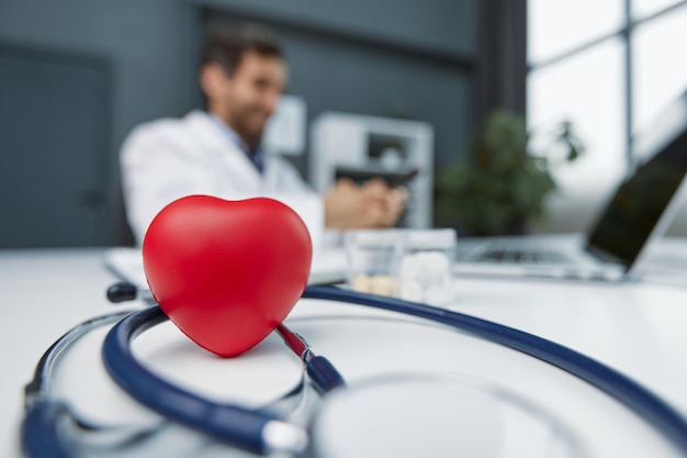 Stethoscope red heart and cardiogram on gray table Cardiology concept