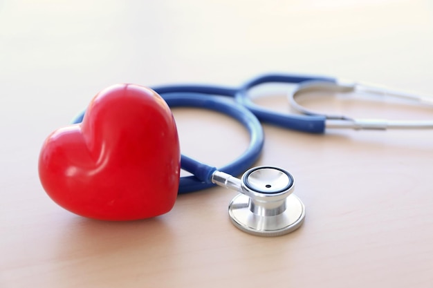 Stethoscope and red heart on wooden table