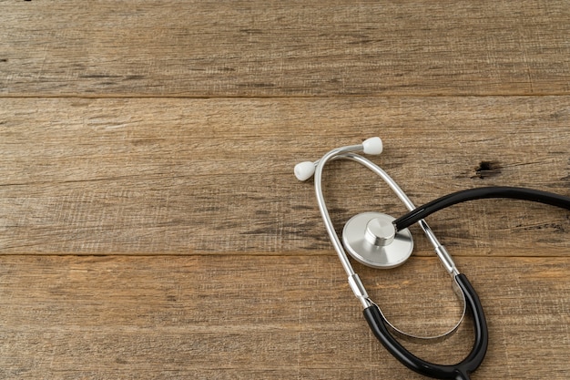 A stethoscope on shabby wooden board. Copy space.