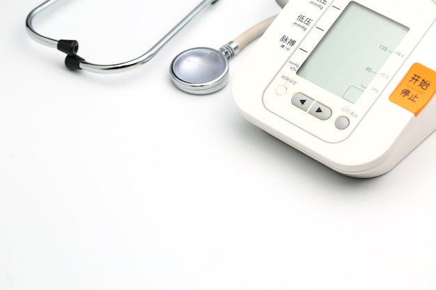 Stethoscope with Electronic Blood Pressure Monitor or Sphygmomanometer on the white background. Healthcare concept.