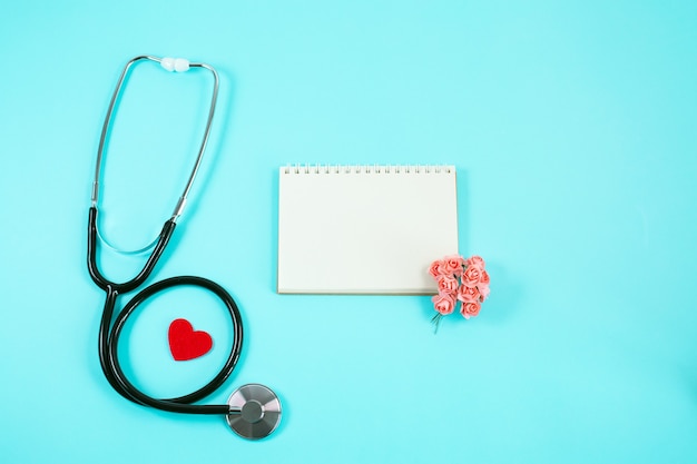 Stethoscope with Red heart, small flowers and notebook