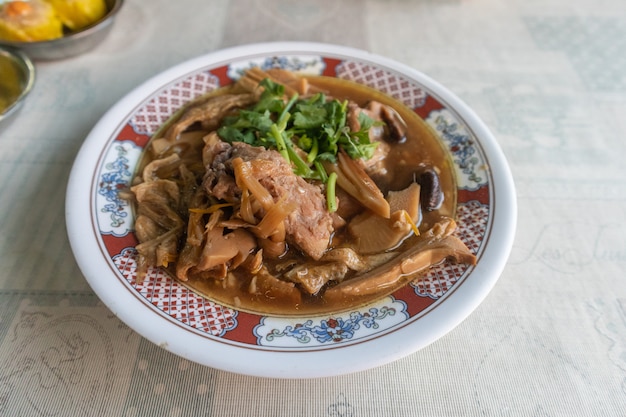 Stew of pork and herbal soup on plate