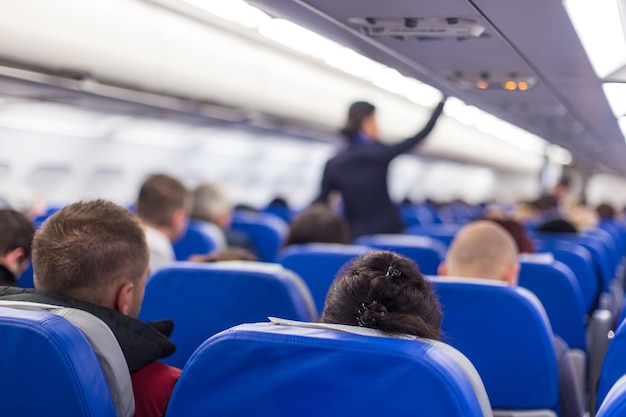 Stewardess walking the aisle of commercial airplane