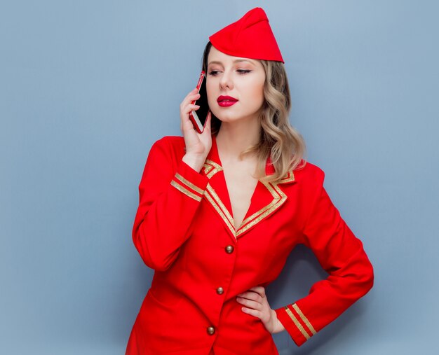 stewardess wearing in red uniform with mobile phone