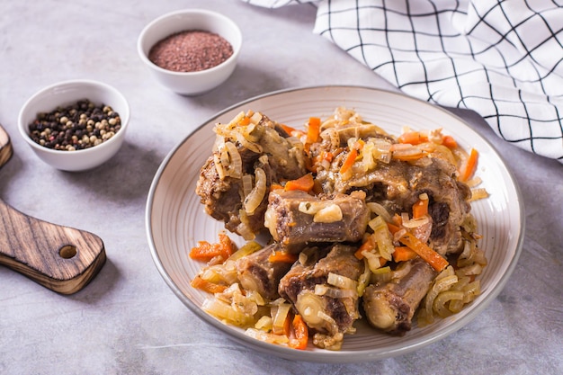 Stewed beef oxtail with wine and vegetables on a plate on the table