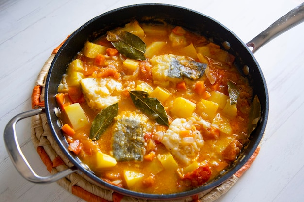 Photo stewed cod with potatoes and vegetables. traditional northern spanish recipe.