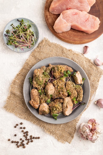 Stewed turkey fillet with sprouts of radish on white wooden background top view close up