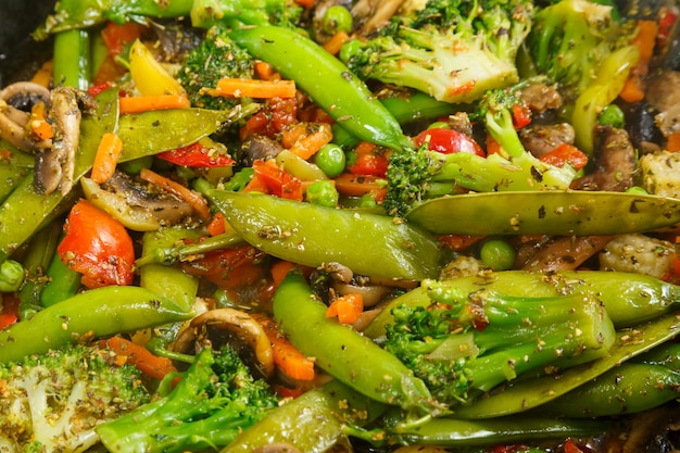 Stewed vegetables broccoli tomatoes and green peas with closeup