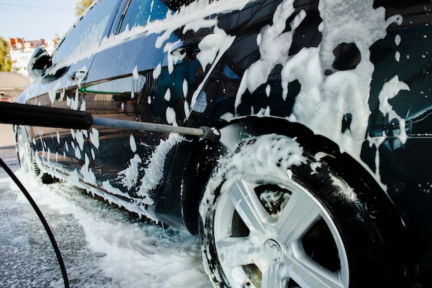 Stick spraying water on a car wheel