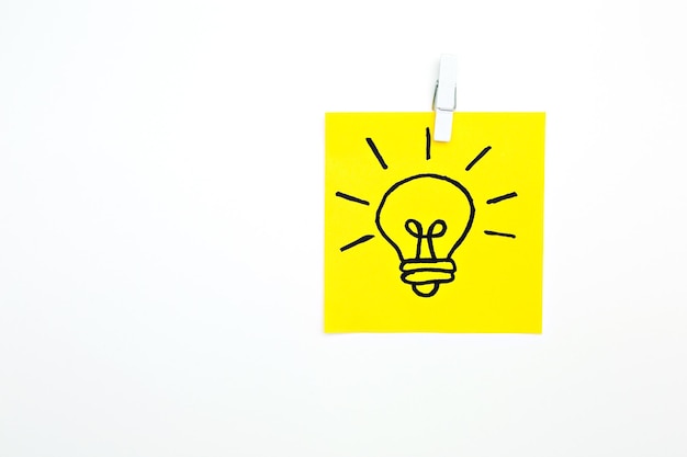 Sticker with a light bulb on a yellow background idea on yellow paper