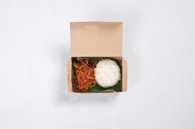 Sticky rice with shredded pork put in a brown paper box, put on a white tablecloth, food box, Thai food.