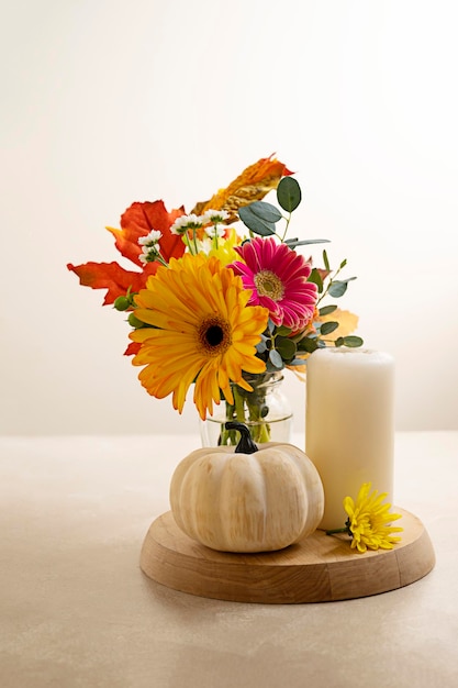 Stil life flowers and pumpkin Bouquet of fresh flowers candle and decorative pumpkins Autumn colorful abstract background