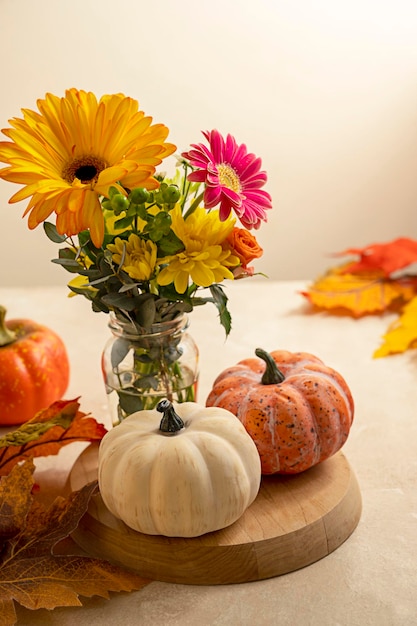 Stil life flowers and pumpkin Bouquet of fresh flowers and decorative pumpkins Autumn colorful arrangement Warm neutral background