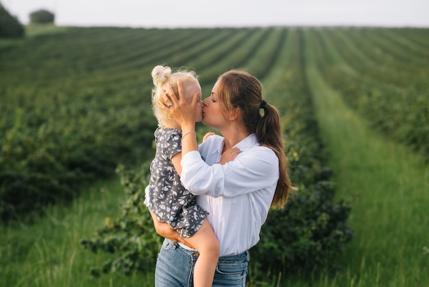 Stilish mother and daughter having fun on the nature.