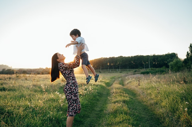 Stilish mother and handsome son having fun on the nature.