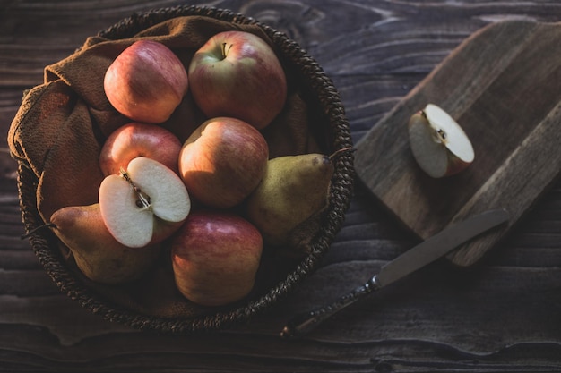 Still life apples in a wicker basket on a wooden table