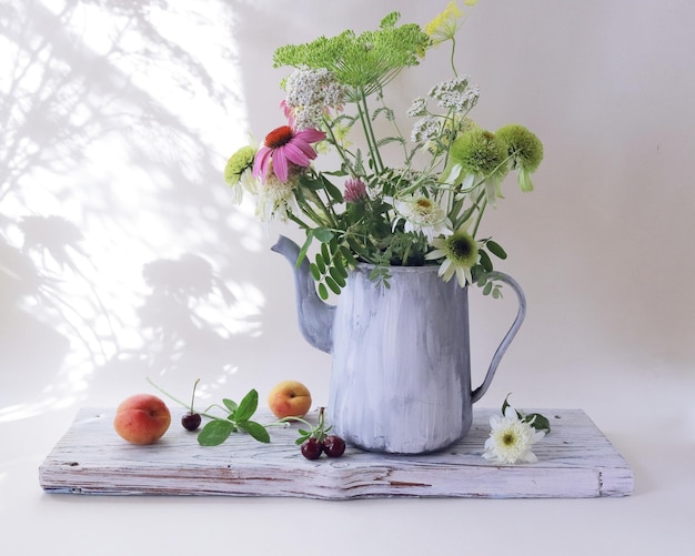 Still life, a bouquet of fresh medicinal flowers and dill seeds, in a jug, on a wooden board