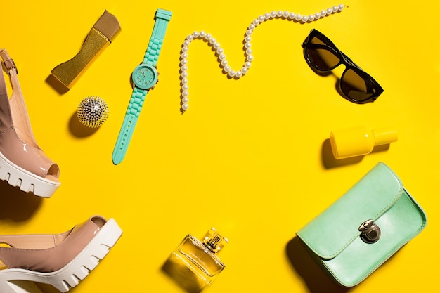 Still life of fashion woman, objects on yellow table