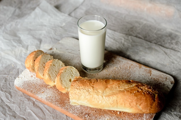 Still life of a glass of milk and sliced bread.