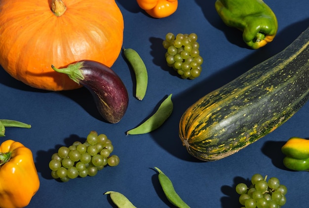 Still life of healthy fresh vegetables and fruits Pumpkinzucchini eggplant grapes peppers and bean podsTrend nature art