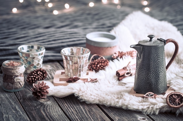 Still life home decorations with a teapot on a wooden background in the interior of the room with light in the background, a holiday concept