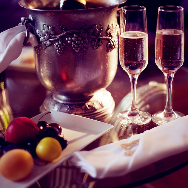 Still life, romantic dinner, two glasses and champagne in the ice bucket. Celebration or holiday