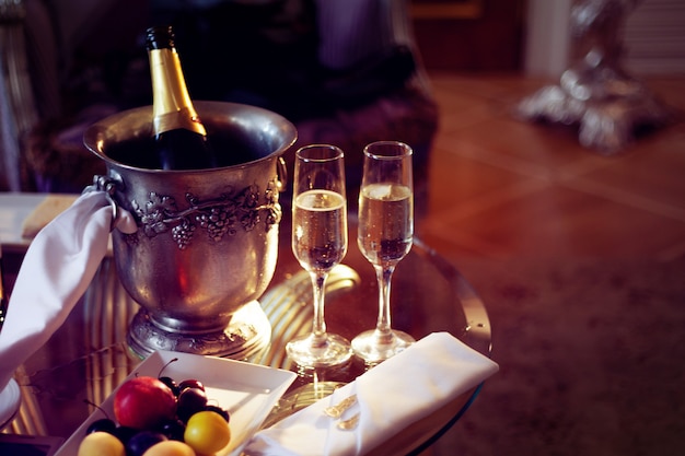 Still life, romantic dinner, two glasses and champagne in the ice bucket. Celebration or holiday