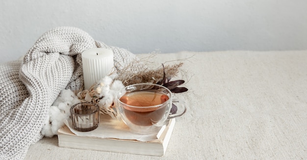 Still life in the Scandinavian style with a cup of tea, a knitted element and a book copy space.