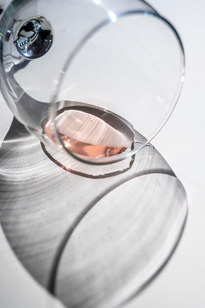 Still life scene with wine glasses on beige background in sunlight with harsh shadows Abstract drinking wine concept