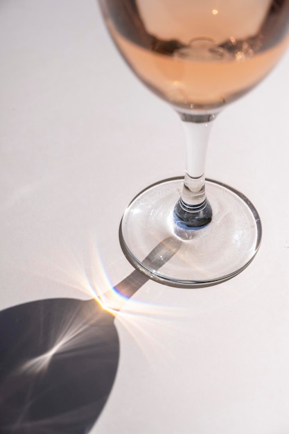 Still life scene with wine glasses on beige background in sunlight with harsh shadows Abstract drinking wine concept