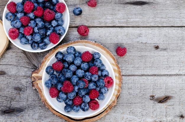 Still life with a blueberries and raspberries on an old wooden table at the garden rural natural foo