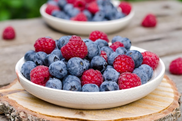 Still life with a blueberries and raspberries on an old wooden table at the garden rural natural foo