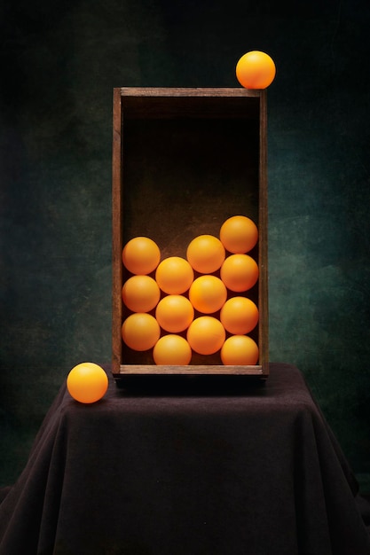 Still life with a box with orange balls