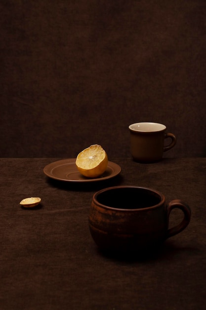 Still life with brown cups and lemon