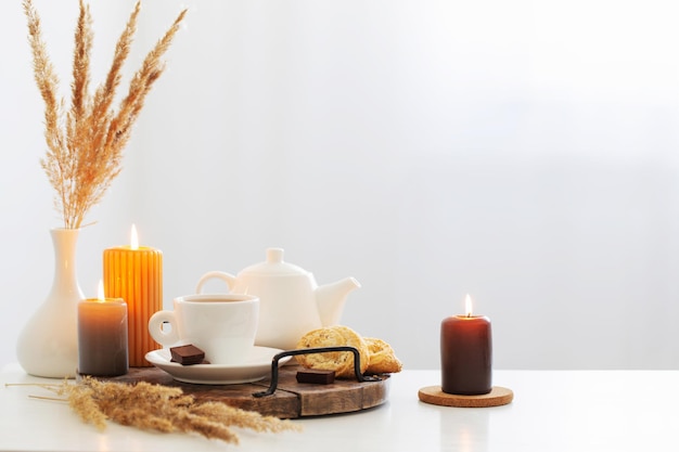 Still life with burning candles in white modern interior