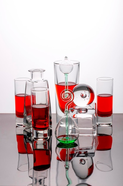 Still life with glassware with liquid on a reflective surface