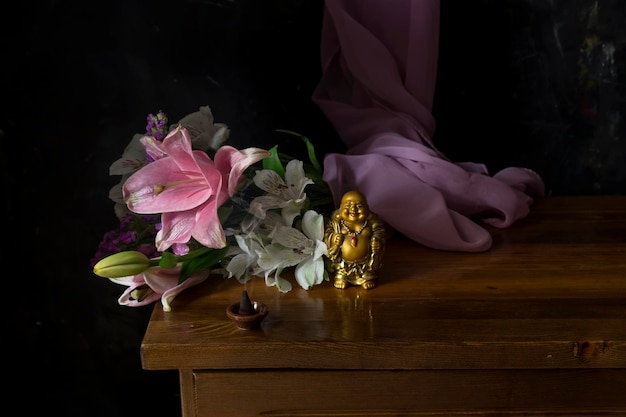 Still Life with laughing Buddha flowers and smoking incense