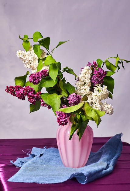 Still life with lilac flowers in a vase on the table.