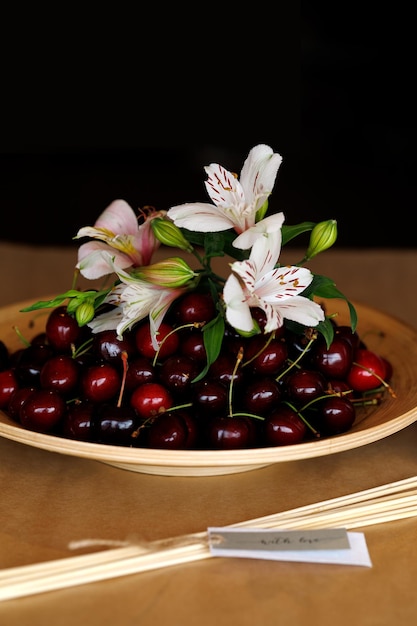 Still life with plate of cherries on the table of master of edible bouquets