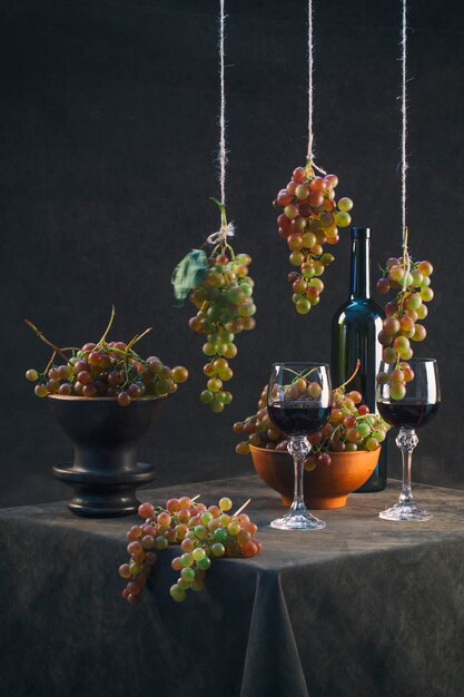 Still life with ripe grapes against and wine