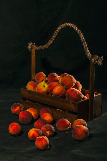 Still life with ripe peaches in a wooden box