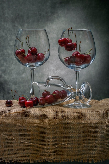 Still life with ripe red cherries in a large glasses