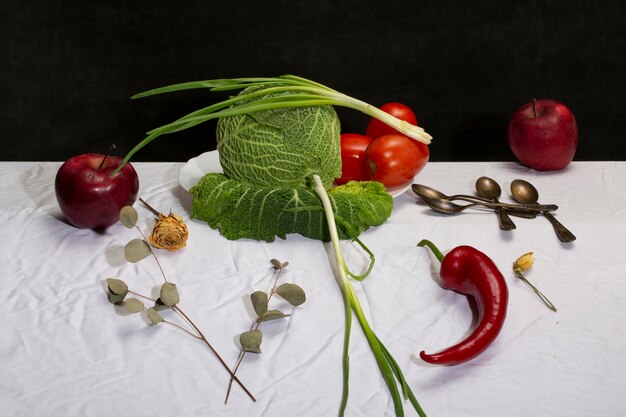 Still life with Savoy cabbage vegetables and fruits on a white tablecloth